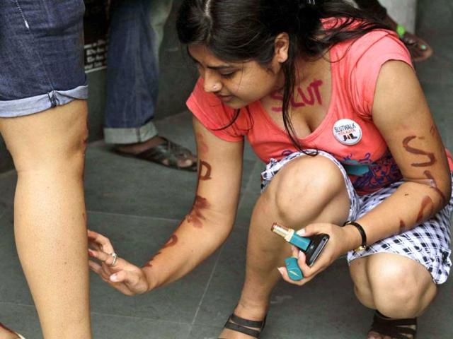 An activist from the LGBT rights movement paints slogans on a fellow activist, prior to the start of a "Slut Walk" in Kolkata. (AP)