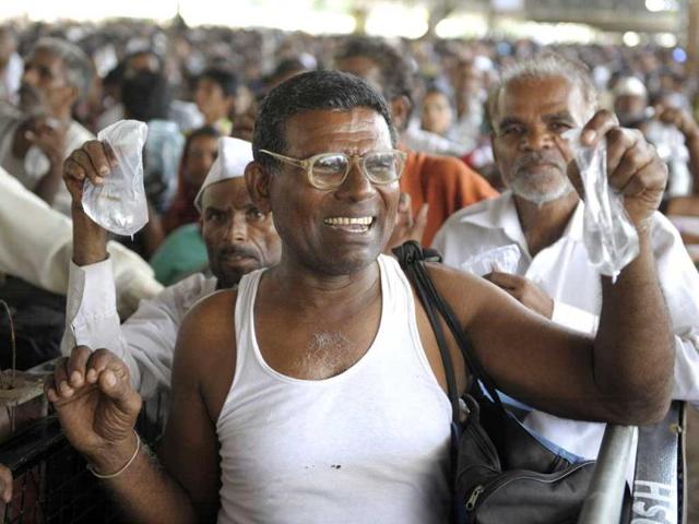 Patients hold up live fishes in plastic bags as they wait to be administered 'fish medicine' by members of the Bathini Goud family at the exhibition grounds in Hyderabad. (AFP)