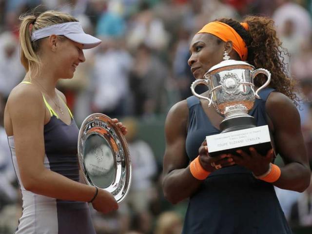 Serena Williams of the US, right, holds the trophy after defeating Russia's Maria Sharapova, left, in two sets 6-4, 6-4, in the women's final of the French Open tennis tournament, at Roland Garros stadium in Paris. (AP)