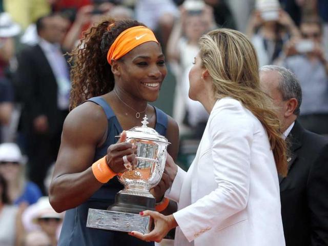 USA's Serena Williams (L) receives her trophy from former tennis champion Aranxta Sanchez following her victory over Russia's Maria Sharapova at the end of their French tennis Open final match at the Roland Garros stadium in Paris. (AFP)