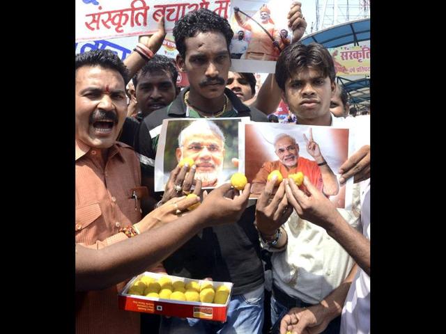 Supporters celebrate as they hold photographs of BJP's new 2014 election campaign head Narendra Modi in Bhopal. AP Photo
