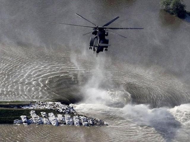 A helicopter of the German armed forces Bundeswehr drops sandbags next to a broken dam built to contain the swollen Elbe river during floods near the village of Fischbeck, in the federal state of Saxony Anhalt. REUTERS
