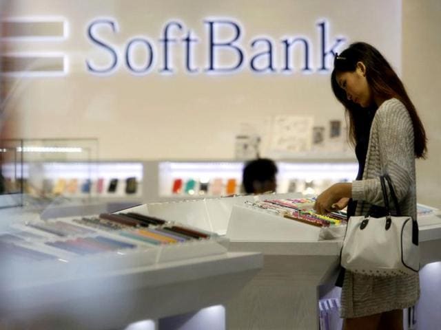 A woman looks at mobile phones at a SoftBank Corp's branch in Tokyo. Japanese mobile operator SoftBank Corp said it agreed with Sprint Nextel Corp to raise its offer for the US wireless carrier to $21.6 billion from $20.1 billion, as it fights off a counter bid by Dish Network Corp. REUTERS