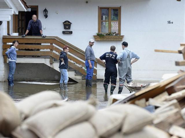 Local residents stand in front of a house that was hit by the floods of the river Danube in Fischerdorf near Deggendorf, southern Germany. AFP