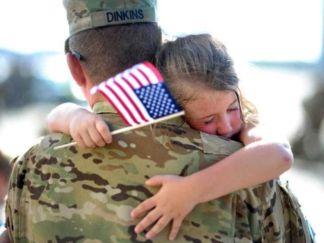 US Army Staff Sgt. Jason Dinkins with the 3rd Combat Aviation Brigade is hugged by his daughter Olivia Chastain after a welcome home ceremony at Hunter Army Airfield in Savannah. (AP)