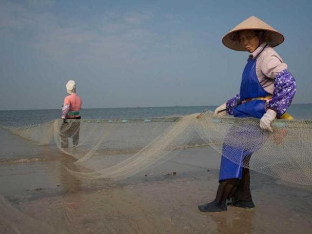 Fishermen collect their net on Silver beach in Beihai in southwestern China's Guangxi province. Widely reported to be the fastest-growing city in China the ancient port city of Behai was historically a major trade hub for the country's southwest, situated off the Gulf of Tonkin between Vietnam and Hong Kong. (AFP)