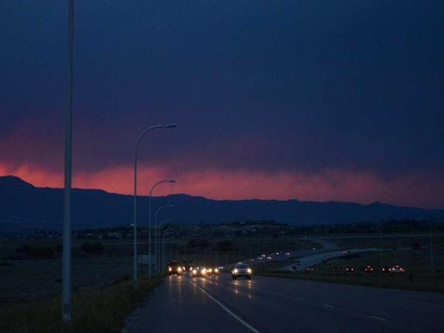 The front range glows an eerie red from the smoke of the Black Forest Fire which continues to burn out of control for a second straight day near Colorado Springs. The fire has consumed 11,500 acres. It has destroyed 92 homes and damaged others. (AP)