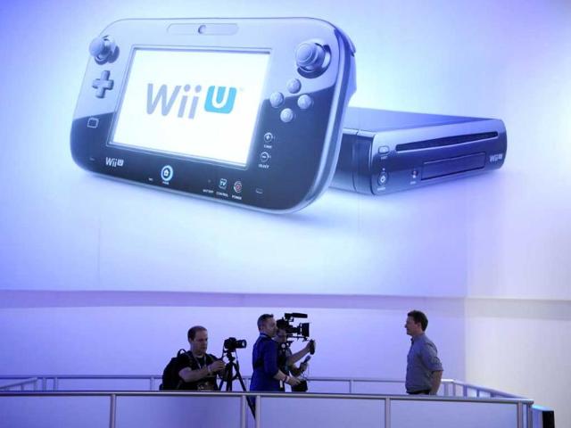 Members of the media work under a photo of the Nintendo Wii U on the final day of the E3 Electronic Entertainment Expo, in Los Angeles, California. AFP