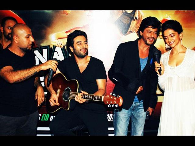 That's like a sport! Shah Rukh Khan and Deepika Padukone croon as the music composer duo plays guitar. (AFP Photo)