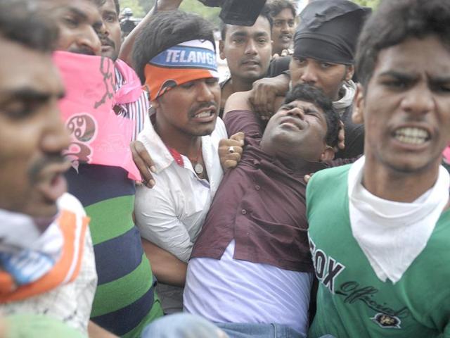A Telangana Joint Action Committee (T-JAC) activist receives assistance from demonstrators during a pro-Telangana protest in Hyderabad on June 14, 2013. AFP/Noah Seelam