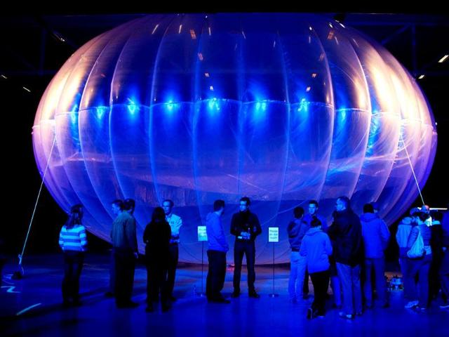 Visitors stand next to a high altitude WiFi internet hub, a Google Project Loon balloon, on display at the Airforce Museum in Christchurch. AFP