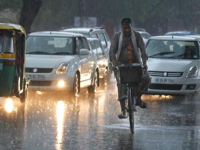A cyclist navigates through the traffic during the first monsoon shower of the season near Mehrauli in New Delhi. HT/Arvind Yadav