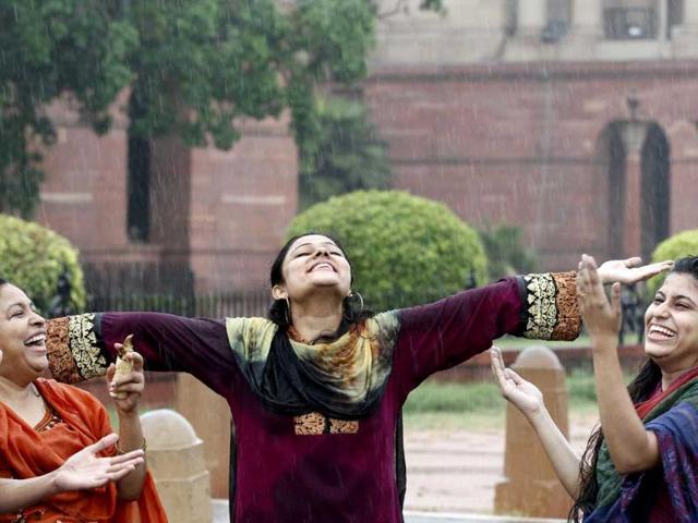A family enjoying the first monsoon shower of the season near South Block in New Delhi. HT/Arvind Yadav
