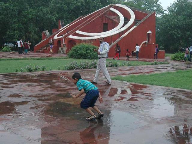 A child playing in a puddle of water after rain, at Jantar Mantar in New Delhi. UNI