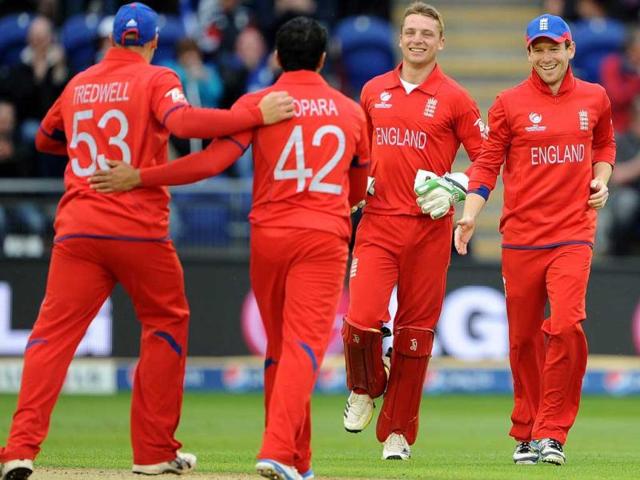 Eoin Morgan (R) celebrates after catching New Zealand's James Franklin during the 2013 ICC Champions Trophy cricket match between England and New Zealand at the Cardiff Wales Stadium in Cardiff, south Wales. AFP Photo