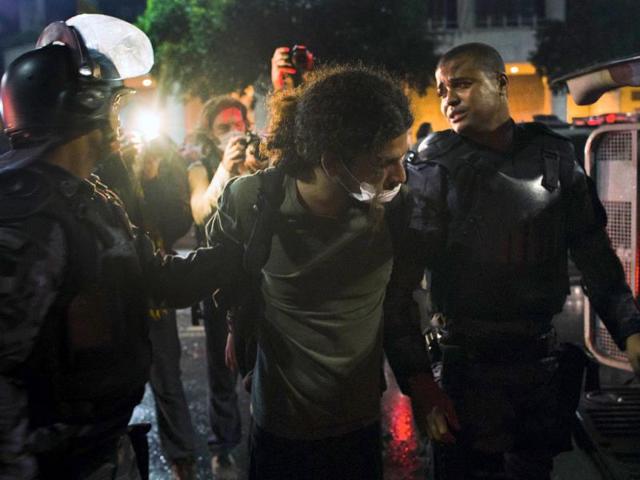 Policemen from the special unit Choque arrest a demonstrator during a protest against corruption and price hikes, in Rio de Janeiro. AFP Photo