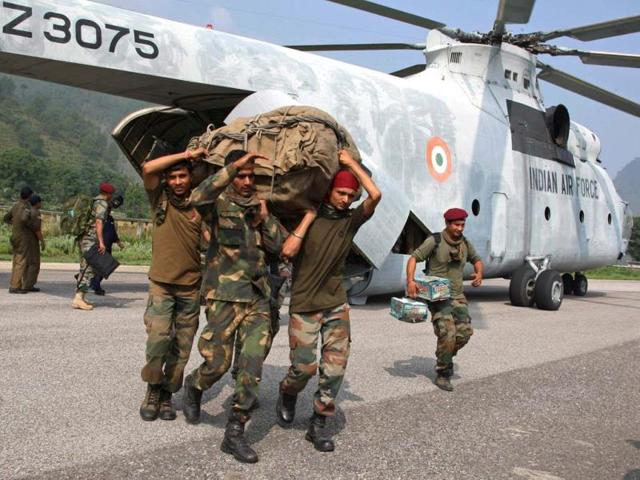 Military personnel carry relief supplies from an Indian Air Force Mi-26 heavy lift helicopter in Ghauri Kund, Uttarakhand. (AFP/Ministry of Defence/Gurudutt Mehra)