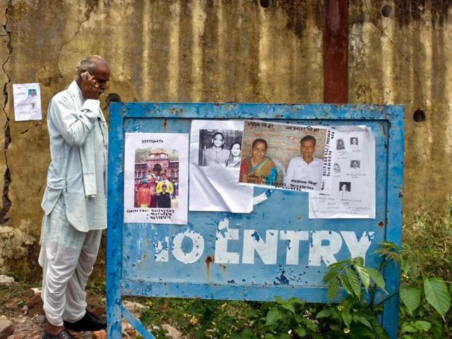 A man talks on his phone while standing near placards bearing portraits of missing pilgrims at the Jolly Grant Airport in Dehradun. (AFP/Ministry of Defence/Gurudutt Mehra)