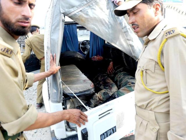 J&K Police stands near the bodies of two Indian army soldiers inside a police vehicle near the scene of an attack by armed rebels in the outskirts of Srinagar on Monday. AFP