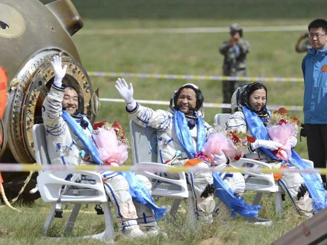 In this photo released by China's Xinhua News Agency, astronauts Zhang Xiaoguang, Nie Haisheng and Wang Yaping, from left to right, wave after getting out of the re-entry capsule of China's Shenzhou 10 spacecraft following its successful landing at the main landing site in Siziwang Banner, north China's Inner Mongolia Autonomous Region. (AP)