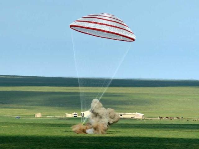 In this photo released by China's Xinhua News Agency, the re-entry capsule of China's Shenzhou 10 spacecraft lands in Siziwang Banner, north China's Inner Mongolia Autonomous Region. The space capsule with three astronauts has safely landed on grasslands in northern China after a 15-day trip to the country's prototype space station. (AP)