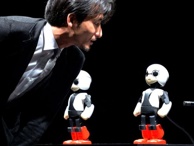 Japanese Tokyo University robot creator Tomotaka Takahashi chats with humanoid robot Kirobo (R) and back-up robot Mirata in Tokyo. (AFP Photo)
