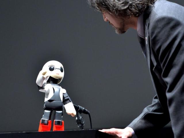 Japanese auto giant Toyota Motor engineer Fuminori Kataoka chats with humanoid robot Kirobo in Tokyo. (AFP Photo)