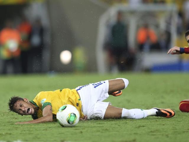 Brazil's Neymar falls after being fouled by Spain's Gerard Pique during the Confederations Cup final match at the Maracana stadium in Rio de Janeiro, Brazil. AP