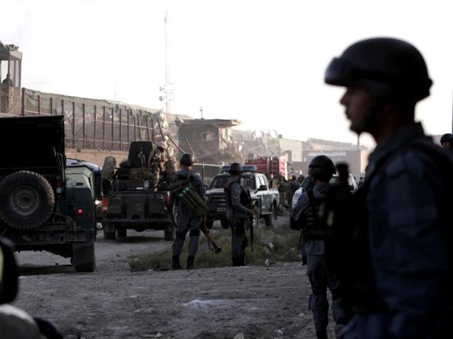 Afghan security officers stand at the entrance gate to a NATO compound in Kabul, Afghanistan after militants blew up a suicide car bomb at the gate. (AP Photo)