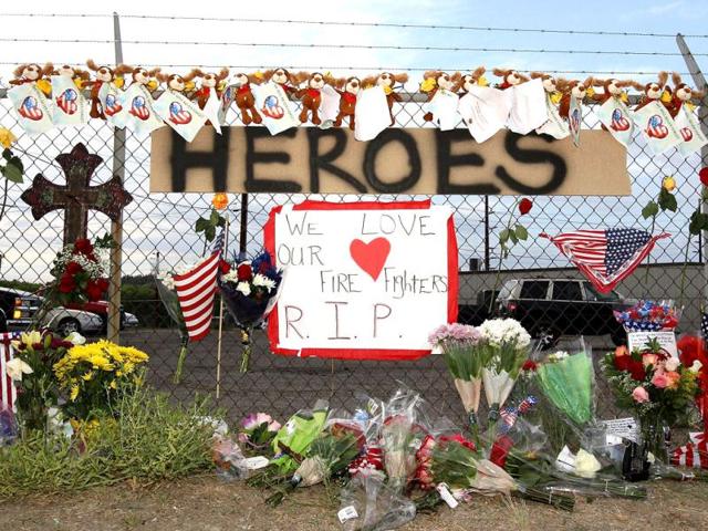 A make shift memorial and a sign reading 'Heroes' is displayed outside of Station 7 in Prescott, Arizona as tribute to 19 firefighters based out of Station 7 died battling a fast-moving wildfire near Yarnell. (AFP Photo)
