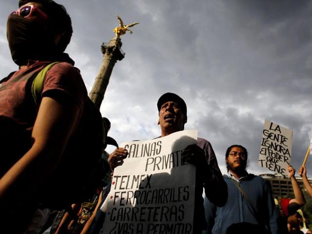 Demonstrators take part in a protest against the privatization of the state oil monopoly Pemex at the Angel of Independence monument in Mexico City. (Reuters)