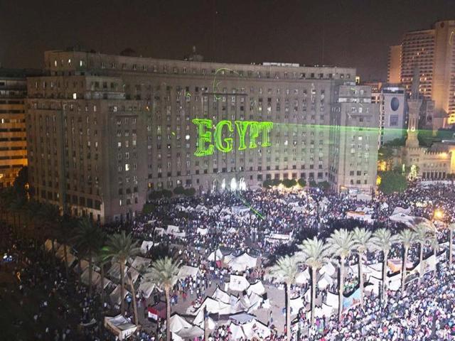 Egyptian protesters calling for the ouster of President Mohamed Morsi gather in Cairo's landmark Tahrir Square as laser lights (L) directed at the government building spell "Egypt." (AFP Photo)