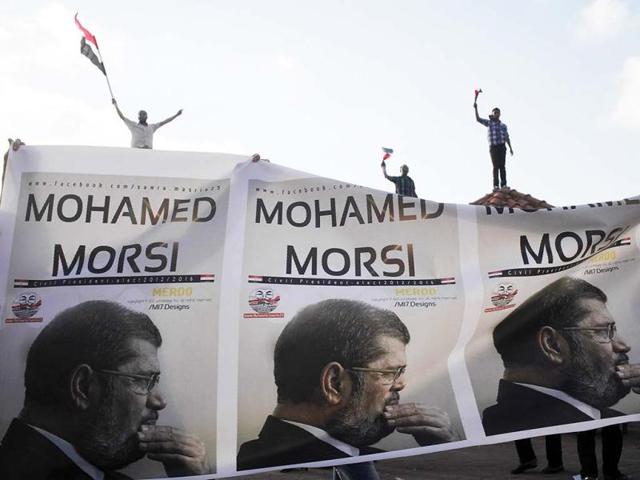Supporters of President Mohamed Morsi carry a banner with his pictures during a protest to counter anti-Mursi protests elsewhere in Alexandria. (Reuters)