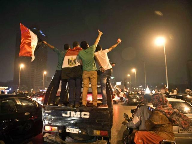 Egyptian youths on police vehicle celebrate in Cairo after a broadcast confirming that the army will temporarily be taking over president Mohammed Morsi. AFP Photo