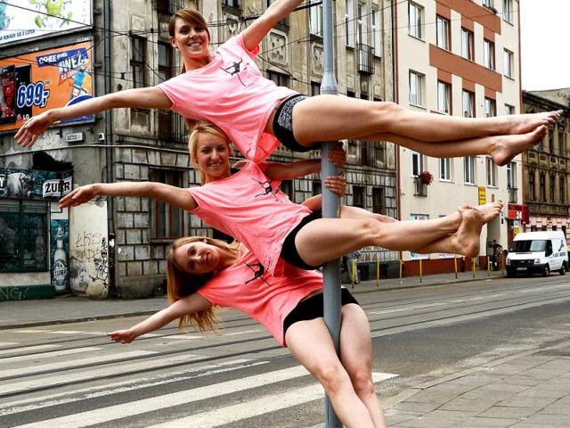 A member of the Avocadoo club performs a pole dance on a street sign pole in Lodz, central Poland. (AFP)