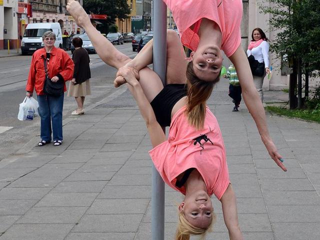 A member of the Avocadoo club performs a pole dance on a street sign pole in Lodz, central Poland. (AFP)