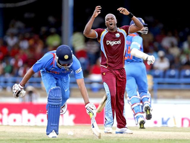West Indies bowler Tino Best (C) reacts after the return missed the stumps and opening batsman Rohit Sharma avoids being run out during their Tri-nation series cricket match in Port-of-Spain, Trinidad. (AP)