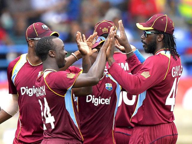 West Indies' Kemar Roach (L) celebrates with teammates after dismissing Shikhar Dhawan during the fourth match of the Tri-nation series between India and West Indies at the Queen's Park Oval in Port of Spain. (AFP)