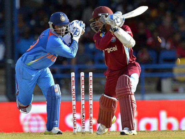 Wicketkeeper Dinesh Karthik (L) unsuccessfully tries a stump-out attempt against West Indies cricketer Denesh Ramdin during the fourth match of the Tri-Nation series between India and West Indies at the Queen's Park Oval in Port of Spain. AFP Photo