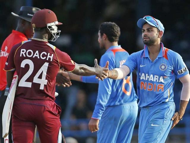 Acting captain Virat Kohli, right, shakes hands with West Indies' Kemar Roach at the end of their Tri-Nation Series cricket match in Port-of-Spain. AP Photo