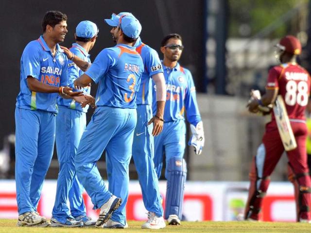 Bowler Umesh Yadav (L) celebrates with teammates after dismissing West Indies' Darren Sammy (R) during the fourth match of the Tri-Nation series between India and West Indies at Queen's Park Oval in Port of Spain. AFP Photo