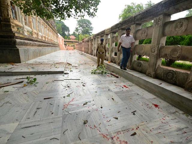 A security officer inspects the site of a blast as blood lies splattered around the Bodhi tree, at the premise of the Mahabodhi Temple in Bodhgaya, about 140kms southwest of Patna. AP