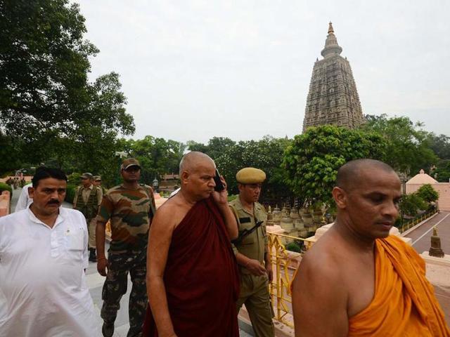 Buddhist monks and security officers walk after a blast on the campus of the Mahabodhi Temple in Bodhgaya, about 140kms southwest of Patna. AP