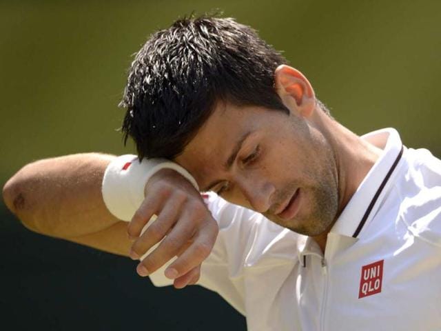 Novak Djokovic wipes his brow between points against Andy Murray during the men's singles final of Wimbledon tournament in Wimbledon. AFP