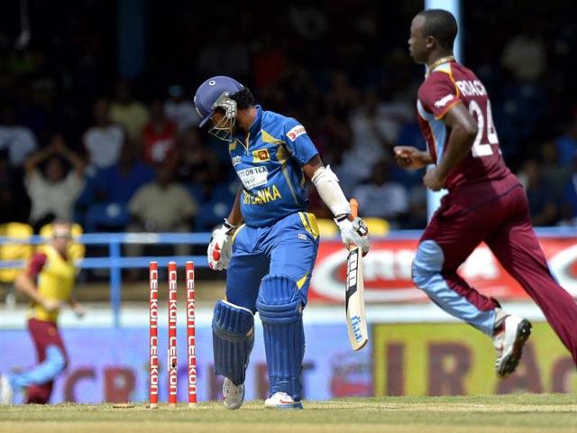 Sri Lankan cricketer Dinesh Chandimal (L) is clean bowled off West Indies bowler Kemar Roach (R) during the fifth match of the Tri-Nation series between Sri Lanka and West Indies at the Queen's Park Oval in Port of Spain. AFP Photo