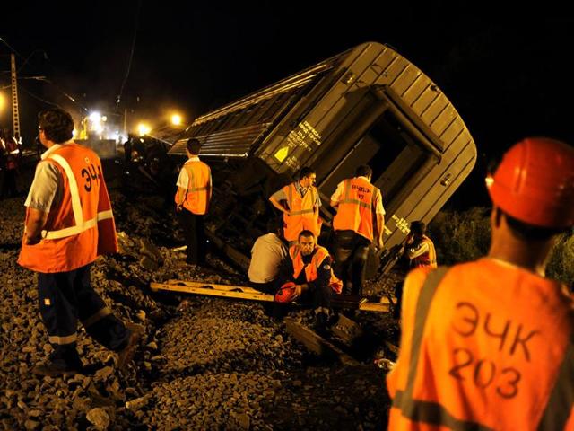 Workers inspect damaged railway carriages and the scene of a train crash on the Kislyakovskaya-Krylovskaya stretch in Russia. (AFP)