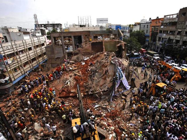 Crowds watch as fire officials and rescue workers look for survivors at the building collapse site.(AP Photos)