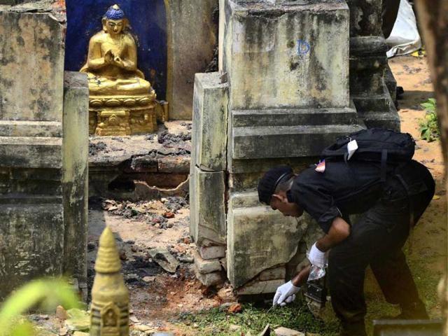 A national security guard soldier collects the evidence from the site of the Mahabodhi Temple in Bodh Gaya a day after the serial blasts. (AP Photo)