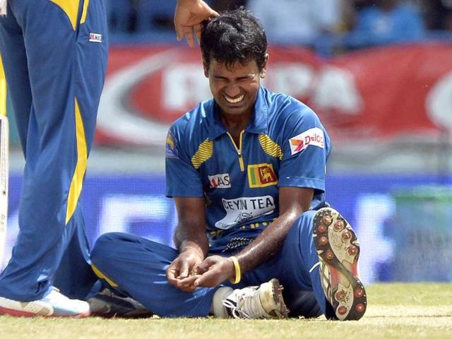 Sri Lankan bowler Nuwan Kulasekara grimaces in pain after getting a gash on the index finger of the left hand by a ball hit by West Indies batsman Chris Gayle during the fifth match of the Tri-Nation series between Sri Lanka and West Indies at the Queen's Park Oval stadium in Port of Spain. AFP Photo