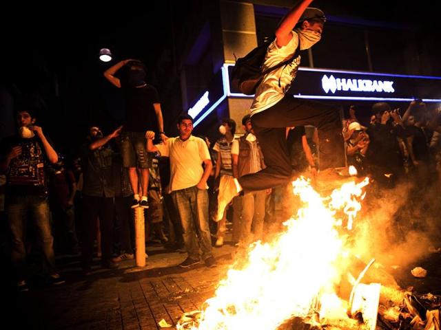 A Turkish protestor jumps over a bonfire during a protest in Istiklal avenue in Istanbul. (AFP Photo)